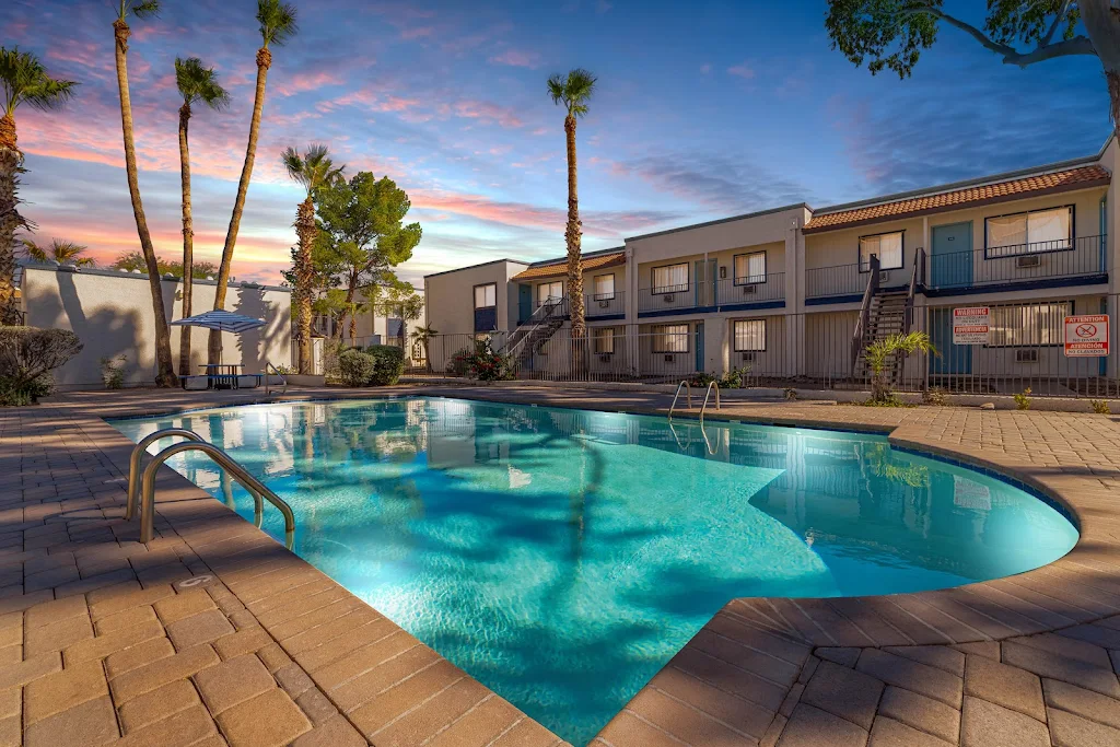 The Crossings on Grande's community pool with view of apartment buildings at dusk