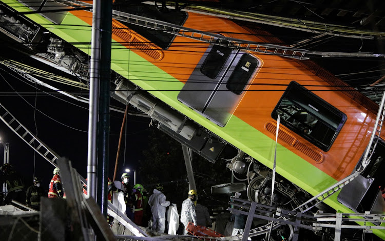 Rescuers work at a site where an overpass for a metro partially collapsed with train cars on it at Olivos station in Mexico City, Mexico, on May 4, 2021.