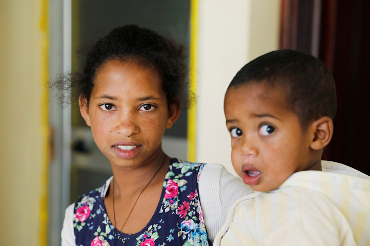 Mibrak Esayus, who says her parents were killed by Eritrean soldiers, holds one of her five siblings at a temporary house, Tigray region, Ethiopia, March 13, 2021.Picture taken on March 13, 2021.