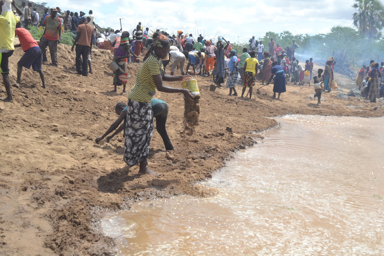 Flood victims trying to block seasonal Kawalase River from swamping their homesteads.