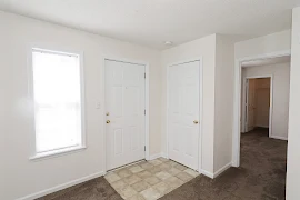 Tiled entryway with storage closet and window with blinds