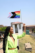 Miss SA Ndavi Nokeri stands next to the pride flag hoisted at Constitutional Hill, Johannesburg.