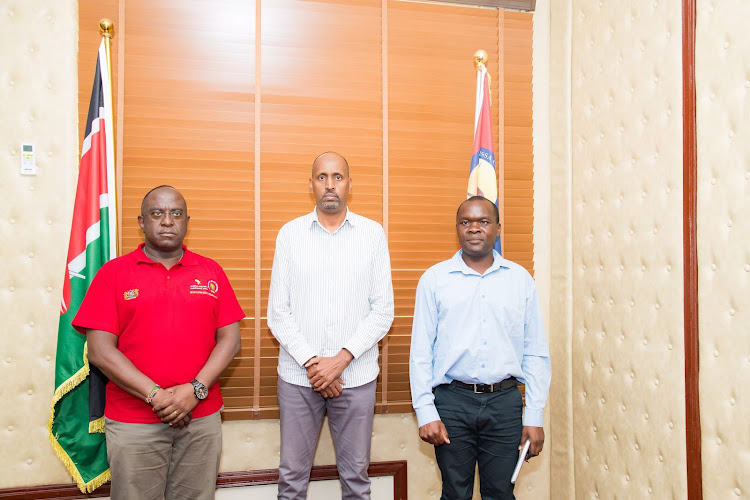 Garissa County Secretary Mohamud Mursal poses for a photo with officials from LAPSSET.