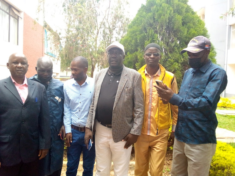 Chris Makokha, Bungoma County DAP-K party ( in white cape) addressing the media at Tourist hotel.