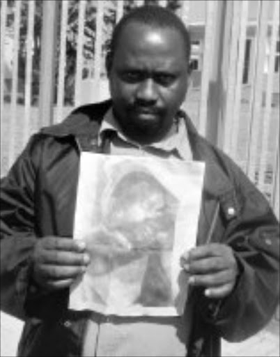 MY BOY: Bhekuyise Mbokazi with a picture of his son's body after it was found dumped in a dam. Pic. Mhlaba Memela. 18/04/2008. © Sowetan.