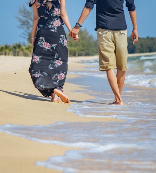 couple walking on beach holding hands