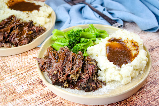 Flavor Filled Pot Roast on a plate with mashed potatoes and broccoli.