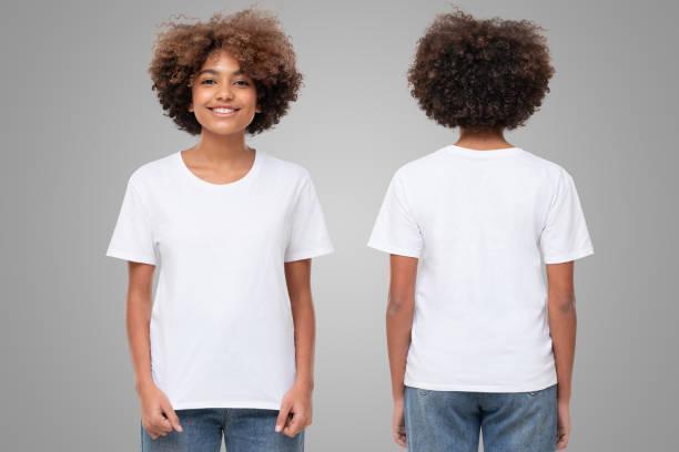 Front and back view of african girl wearing blank t-shirt with copy space on gray background Front and back view of african american girl wearing blank t-shirt with copy space, isolated on gray background tee shirts stock pictures, royalty-free photos & images