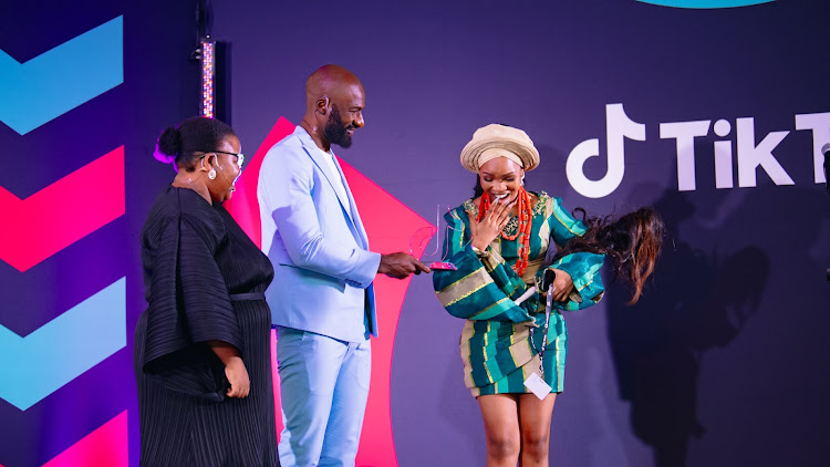 Dennis Ombachi aka The Roaming Chef presents the trophy for 'Lifestyle and Education Creator of the Year in Sub-Saharan Africa' to Iremide at the 2023 TikTok Top Creator Awards at Vodacom World in Johannesburg on February 9 2024.