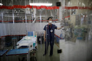 St. Marianna University Yokohama Seibu Hospital doctor Hiroki Saito is seen through plastic curtains at emergency and critical care room inside the hospital where patients suffering from Covid-19 are being treated in Yokohama, south of Tokyo, Japan, on May 25 2021. 