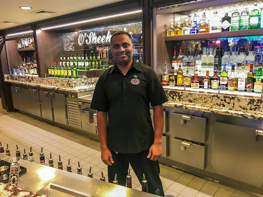 Bartender-in-O'Sheehan's.jpg - A bartender mans the bar just before the joint gets jumping at O'Sheehan's on Norwegian Jade. 