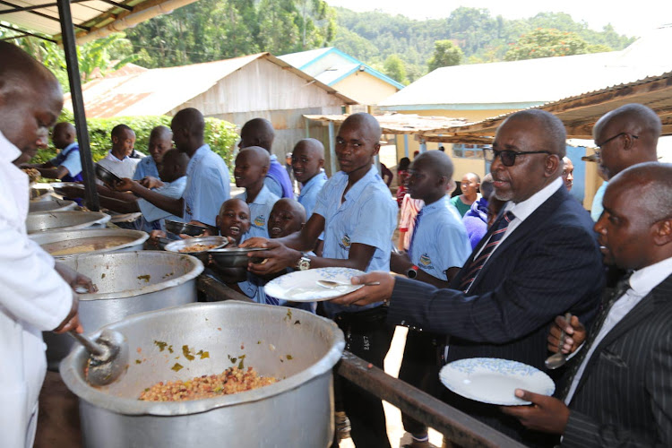 Agriculture CS Mithika Linturi queues for githeri with students at Igembe Boys Secondary School in Meru on January 27, 2023.