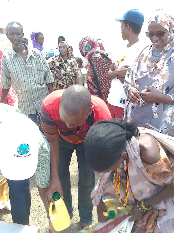 Hunger-stricken residents of Maikona receive relief food. The CEC member Transport, Roads, Housing and Public works Guyo Guracha led the exercise.