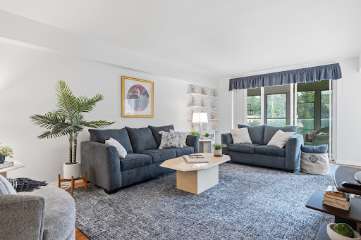 Living room with two blue sofas and plant in this luxury house for sale in Nyack ($315,000)
