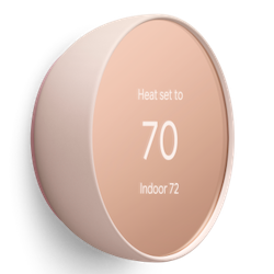 Angled view of a Nest Thermostat with a mirrored round display and coral housing