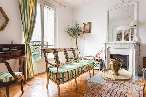 Living room with sofa, fireplace, and desk in this luxury apartment for sale in Paris 7ème ($1,153,141 - 73 m²)