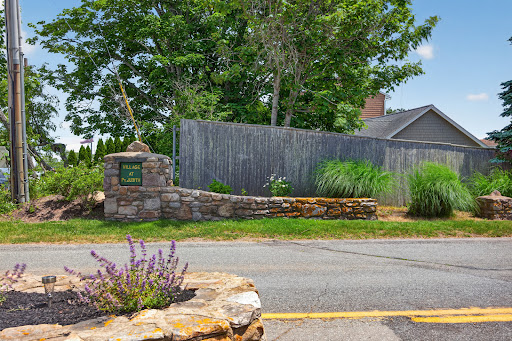 Stone entrance sign with greenery in this luxury house for sale in Narragansett ($895,000)