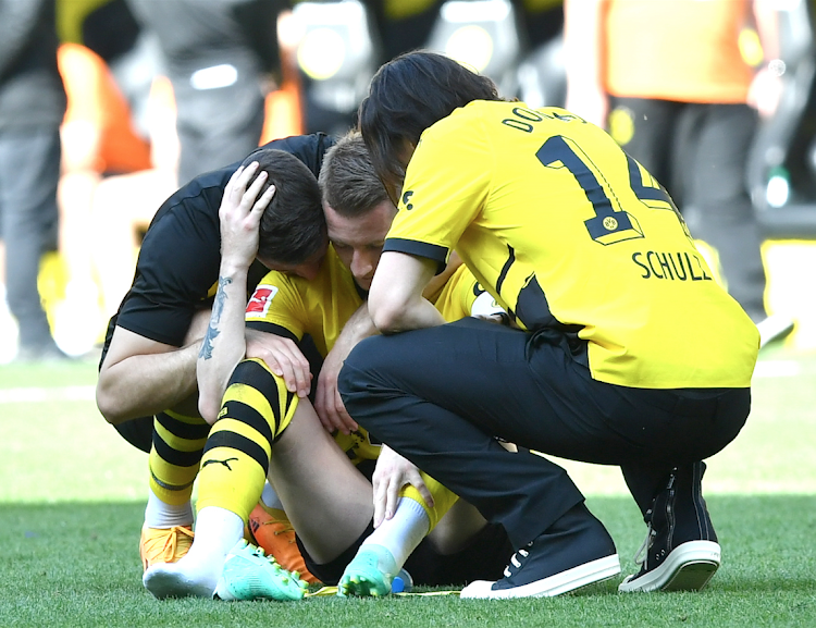 Marco Reus (C) of Dortmund is comforted by teammates after their match against Mainz