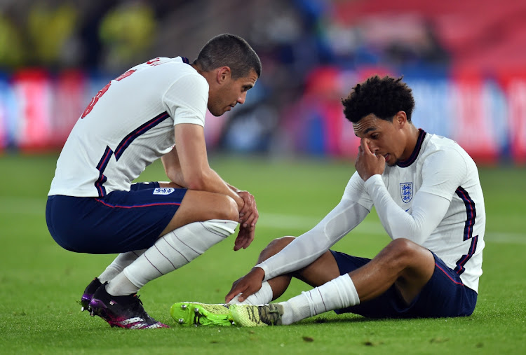 England's Trent Alexander-Arnold after sustaining an injury as Conor Coady looks on.