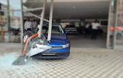 The vehicle came to a halt after bursting through the dealership windows.