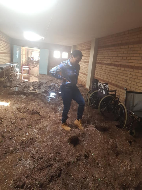 Limpopo's MEC for health, Phophi Ramathuba, makes her way through the mud in Jane Furse Hospital.