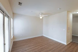 Living room with wood-inspired flooring, a ceiling fan, neutral walls, and white trim 