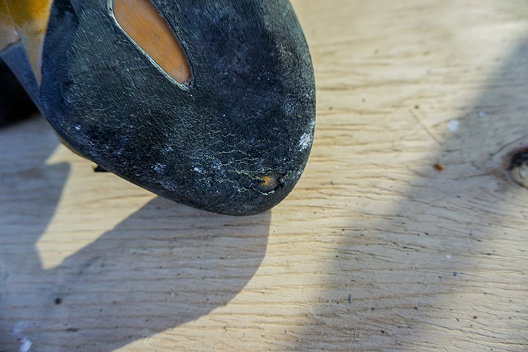 A hole worn through on the outsole of a climbing shoe