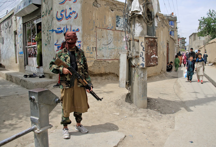 A Taliban fighter stands guard at the site of an explosion in Kabul, Afghanistan, April 19, 2022.