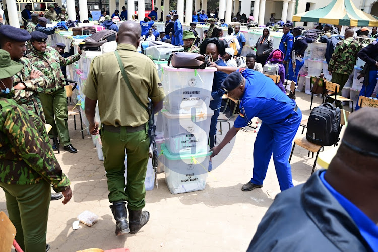 Police officers moving the ballot boxes for verification at Jamuhuri High school Starehe constituency polling station on Wednesday, August 10,2022.