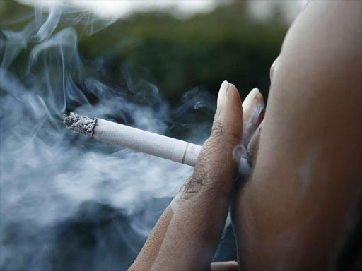 A smoker puffs at a cigarette.