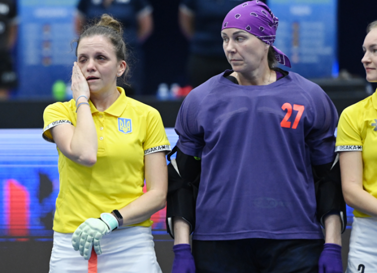 Ukraine captain Yevheniia Moroz wipes a tear during the playing of the Ukraine anthem at the Indoor Hockey World Cup in Pretoria. To her left are teammates Tetiana Stepachenko, the goalkeeper, and Kateryna Kasianova.