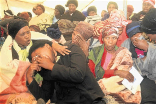 A VILLAGE GRIEVES: Family members weep during the funeral of one of the Marikana victims, Thembinkosi Gwelani, at Lusikisiki in Eastern Cape. PHOTO: LULAMILE FENI