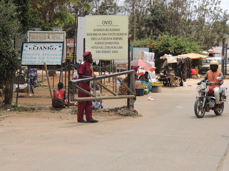 A Tanzanian security official opens a barrier for a boda boda rider at Sirari border post in Tanzania on Wednesday.