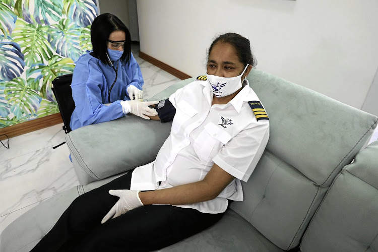 Covid-19 survivor Fathima Khan Gabie is examined by nurse Claire van Staden at home in Durban North.