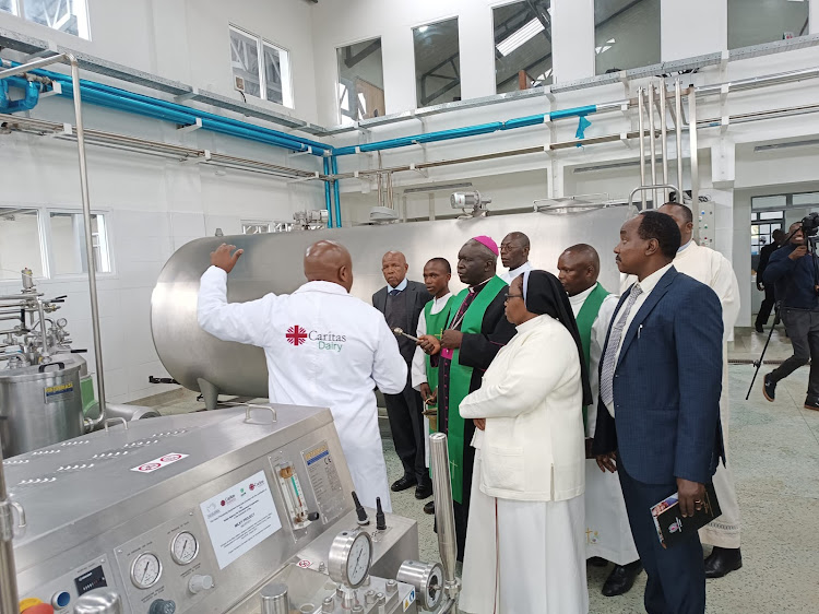 Nairobi Catholic Archbishop Phillip Anyolo is taken through the Caritas Nairobi’s milk processing plant at the church's farm in Tigoni, Limuru