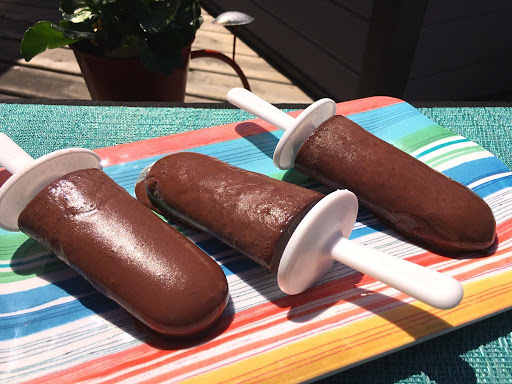 Three fudgesicles on a plate.