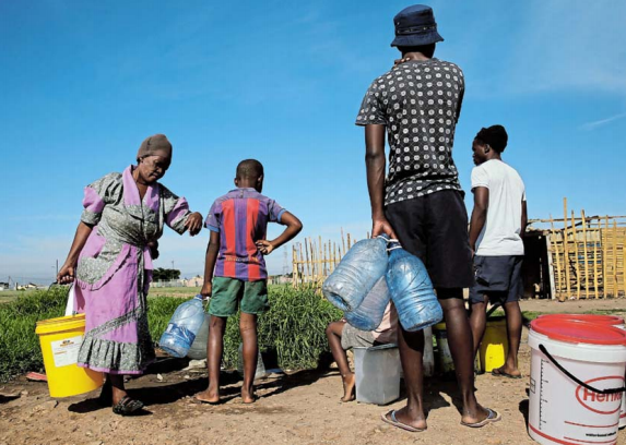 Residents of the Nomakanjani informal settlement queue to use a communal tap