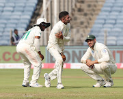 Keshav Maharaj of South Africa reacts in pain after injury as Aiden Markram and Temba Bavuma look on. 