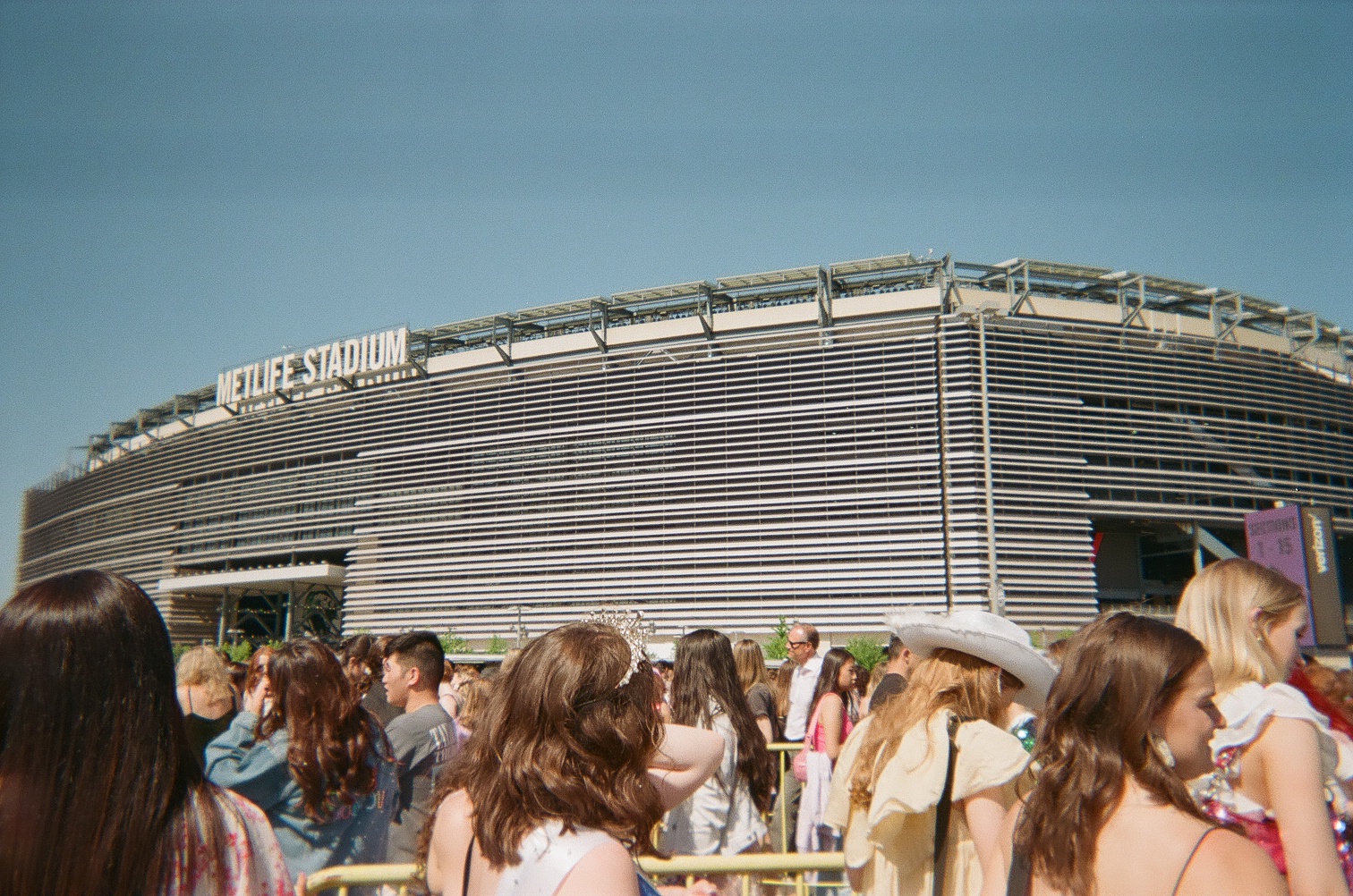 A crowd of people in line in front of MetLife Stadium.