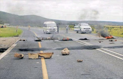 FED-UP: Bedford residents angry with the lack of service delivery from Raymond Mhlaba local municipality blocked off the R63 with burning tyres and rocks between their town and Adelaide yesterday Picture: ZOLILE MENZELWA