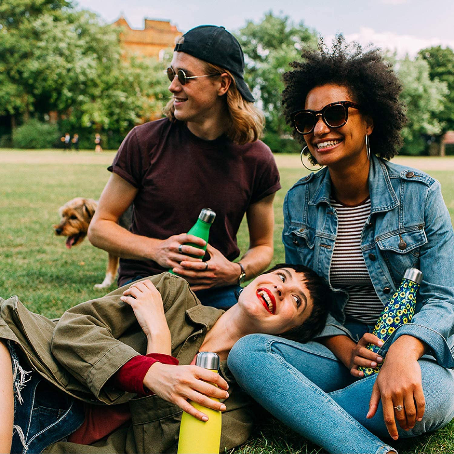 Personnes sur l'herbe tenant des gourdes de differentes couleurs