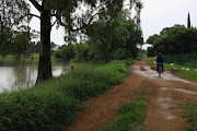 A man cycles past the massive body of water. 