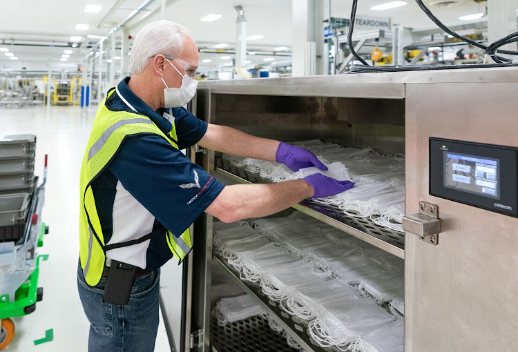 A GM factory worker packs away face masks.