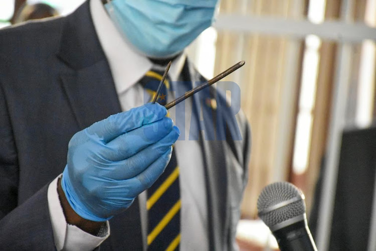 The prosecutor holds a nail bar that was used to drill the hole at Kamiti Prison which the accused escaped from at Kahawa law court on 29, November 2021./MERCY MUMO