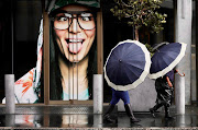 People walking on the streets as heavy rainfall hits Cape Town. 