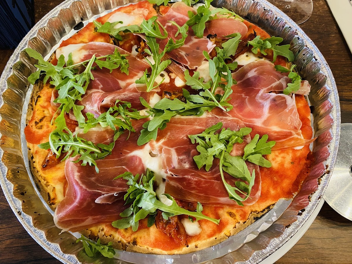 GF prosciutto pizza with  arugula and vegan cheese