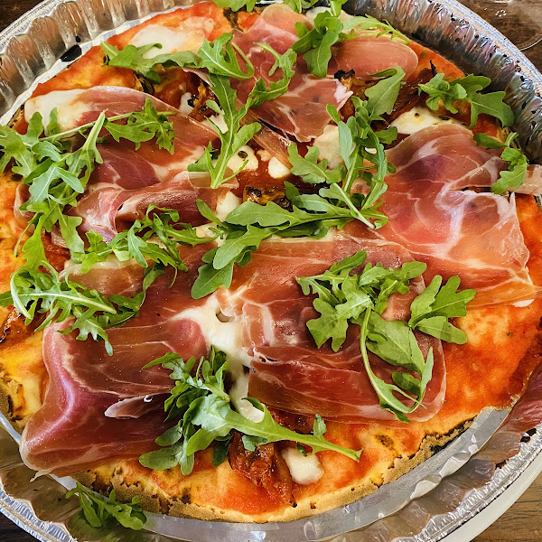 GF prosciutto pizza with  arugula and vegan cheese