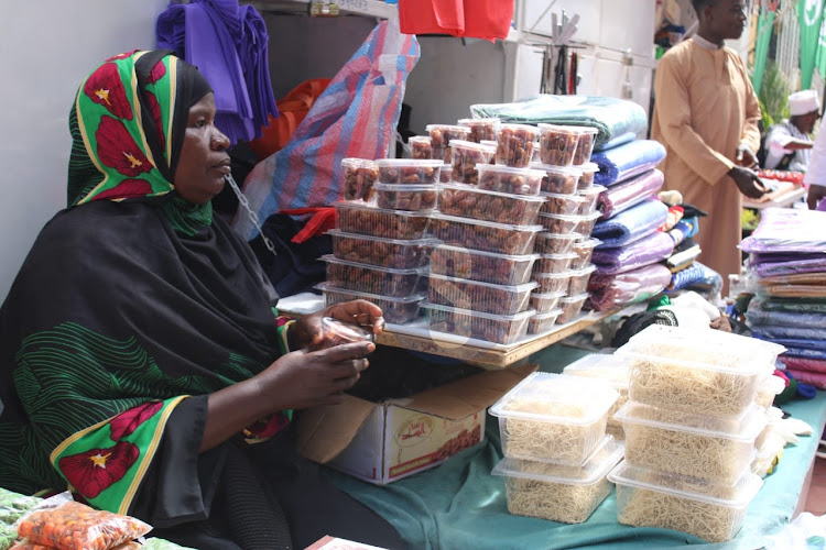 A vendor Fatma Tatu arranges food stuffs for customers during the Eid Mubarak celebrations outside Jamia mosque, Nairobi on April 10, 2024