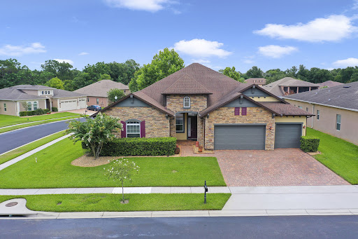 Brick house facade and manicured lawn in this luxury house for sale in Ocoee ($725,000)