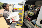 HEAVY BURDEN: A shopkeeper in Soweto loads stock into a minibus in an attempt to escape marauding mobs of looters attacking shops owned by foreigners, apparently in retaliation for the fatal shooting of a 14-year-old boy, Siphiwe Mahori, on Monday night